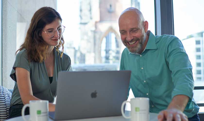 Zwei Hamburger cronn-Mitarbeiter:innen an einem Laptop.